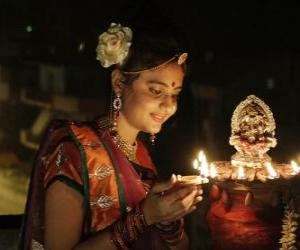 Układanka Kobieta klęczy z lampy naftowej w niej strony w obchodach Diwali
