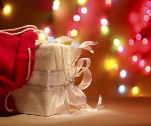 Układanka prezent na Boże Narodzenie zawinięte w biały papier i urządzone z łuku