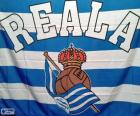 Flaga Real Sociedad, składa się z czterech paski niebieskie i trzy białe na tej samej szerokości, słowo REALA i logo