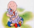 Caillou siedzi na podłodze i przytula swojego kota Gilbert