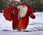 Santa Claus prowadzenia wielki worek na prezenty świąteczne w lesie