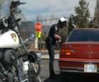 Policjant Motorized z jego motocykla i umieścić grzywny na kierowców