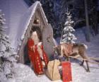 Santa u drzwi domu z reniferów i prezentów