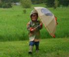 Chłopiec z jego parasol i kurtkę na deszcz wiosenny deszcz