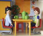 Szczęśliwa rodzina Playmobil jedząca przy kuchennym stole