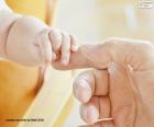 Dziecko podnosi palec ojca
